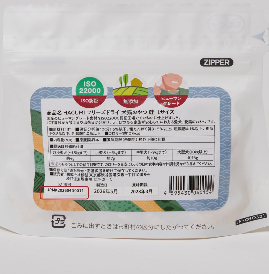 HAGUMIパッケージ（フリーズドライ鮭）裏面の写真。ラベル左下の白いシールにLOT番号（例：JPMK202604D0011）が記載され、赤枠で示されています。